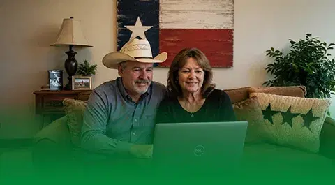 Couple reviewing paperwork at home with framed Texas flag, representing Texas debt consolidation and debt relief services
